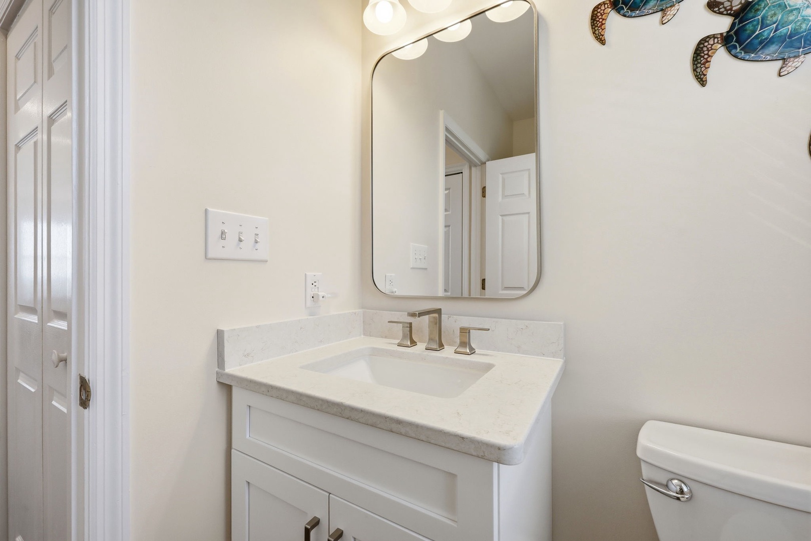Your private bathroom features a marble vanity, modern fixtures, and coastal-inspired décor—a serene spot to refresh each morning.