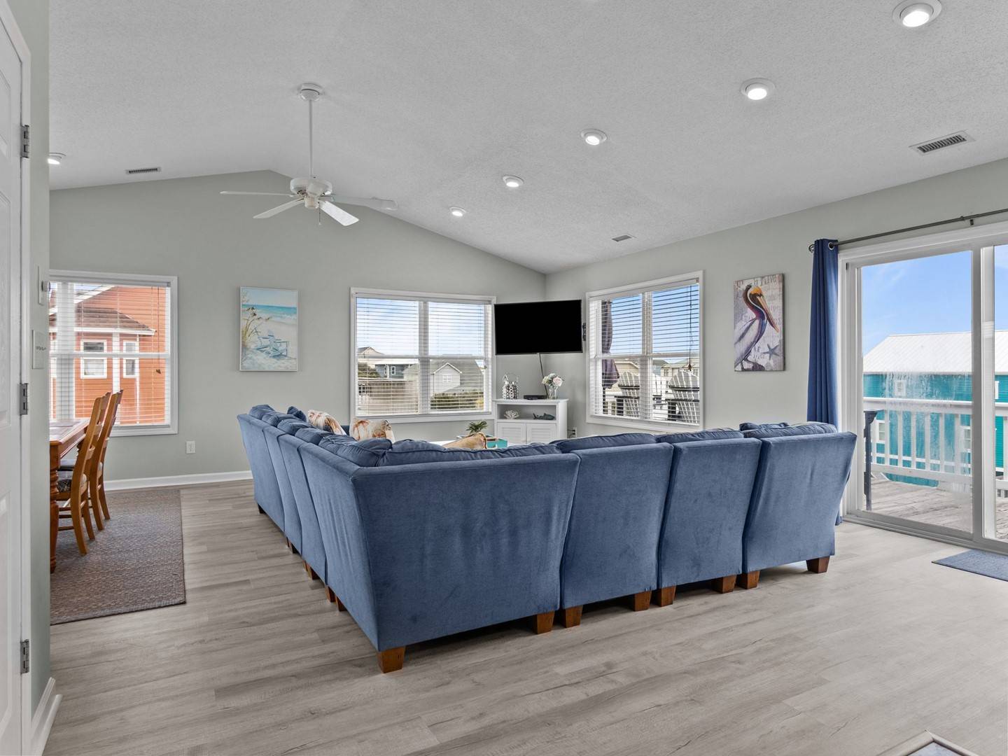 Sink into plush blue sofas while enjoying ocean views through expansive windows in your bright, airy living space.