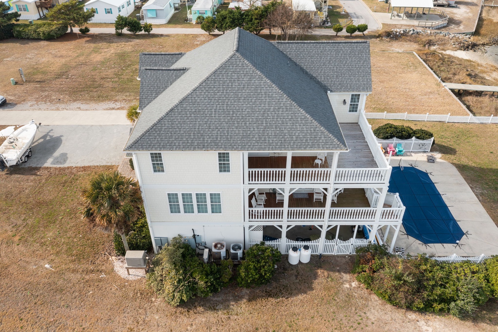 A stunning white coastal home featuring wraparound porches, private pool, and prime location in a peaceful beach community.