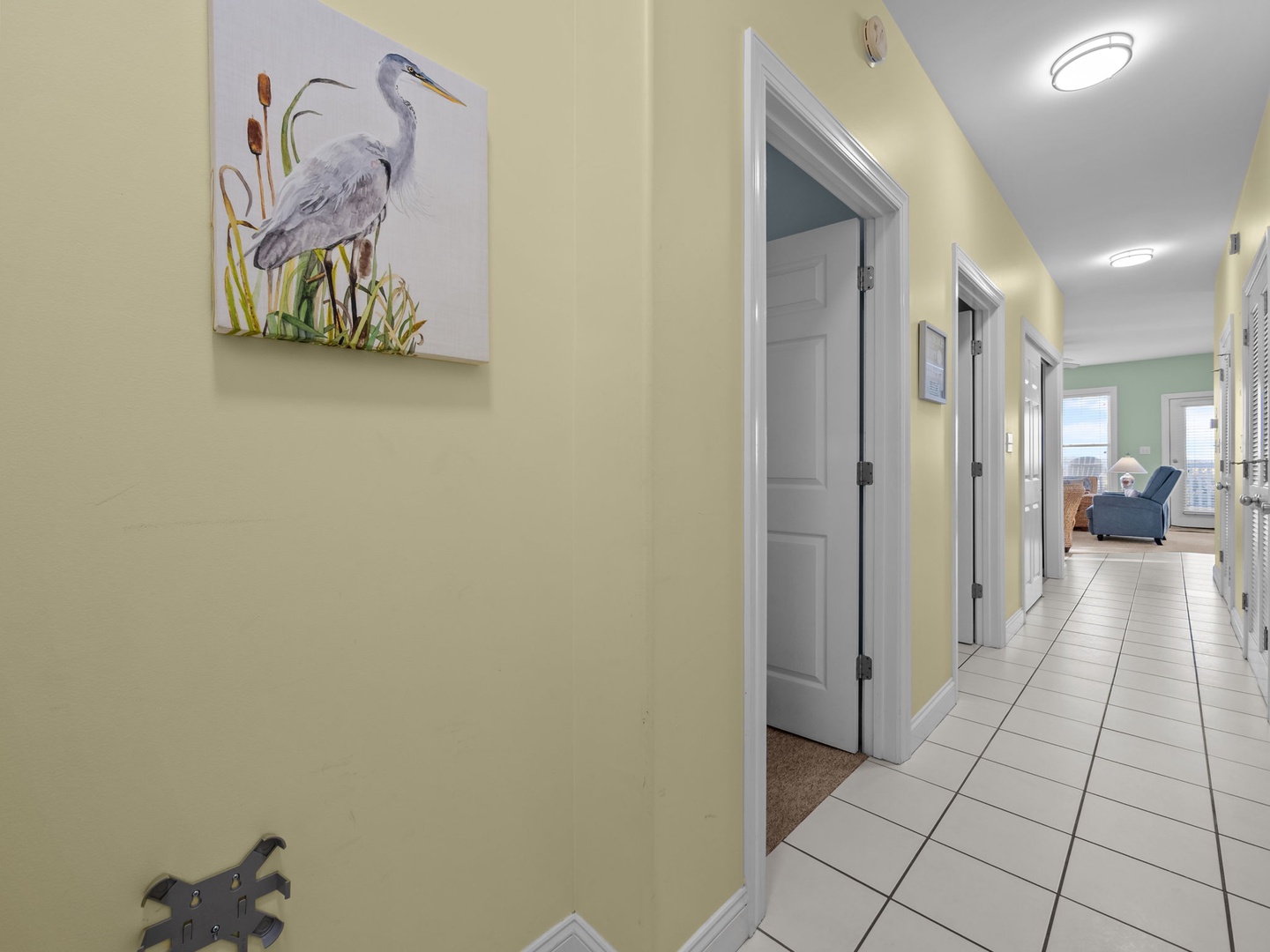 Your private hallway leads to cozy rooms, with beautiful coastal artwork and clean tile floors welcoming you home after beach days.