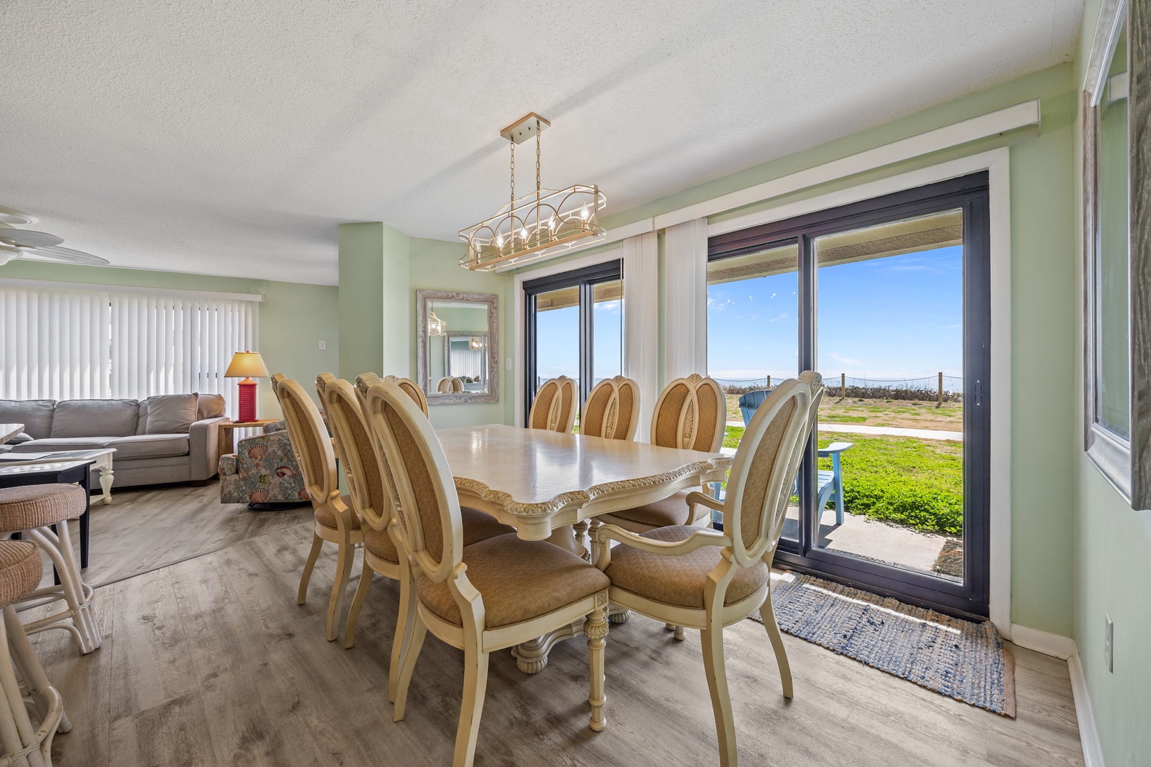 Gather around your elegant dining table where morning coffee and evening meals come with sweeping water views through floor-to-ceiling windows.