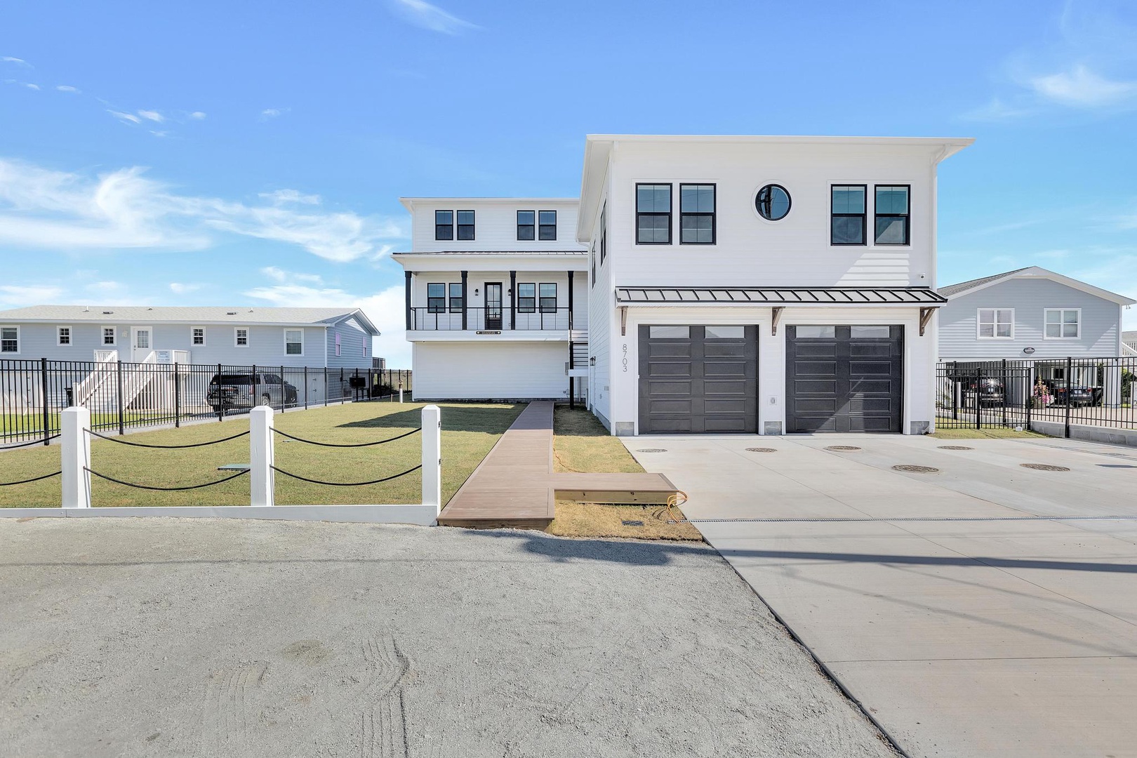 Modern coastal vacation home featuring a two-car garage, contemporary architecture, and coastal neighborhood setting with easy beach access.