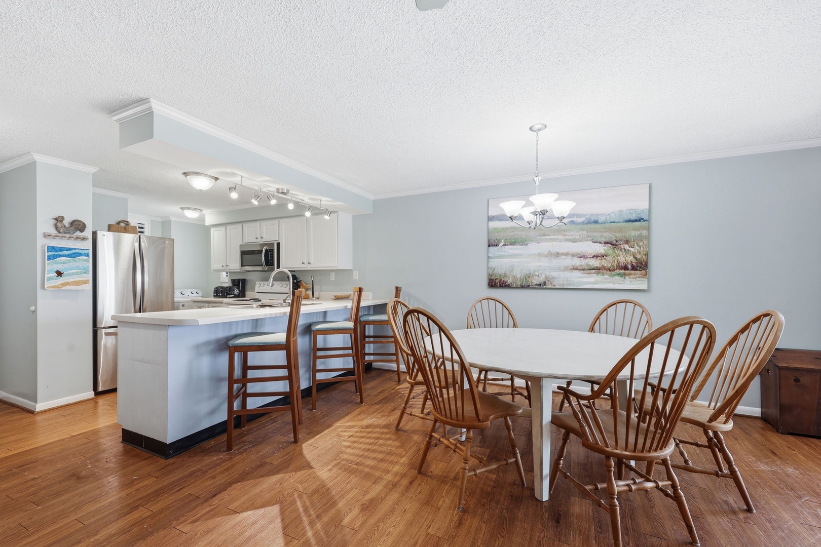 Gather around the generous dining table with seating for eight, opening seamlessly to your fully equipped kitchen with stainless steel appliances and breakfast bar.