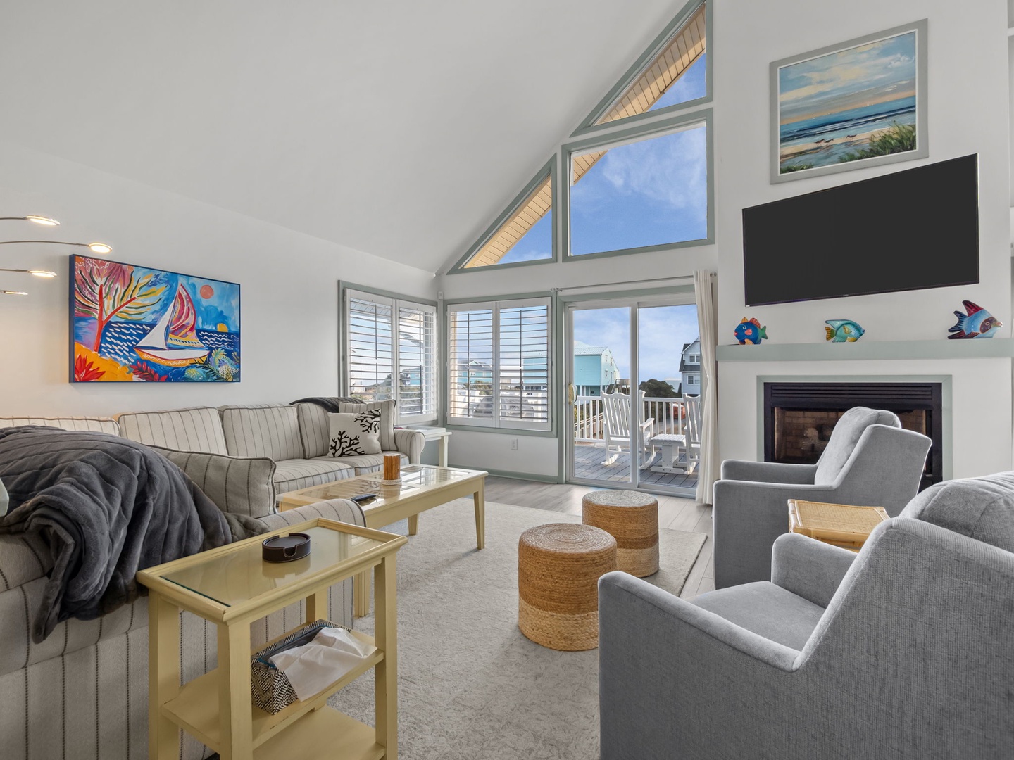 Sink into plush seating by your cozy fireplace while ocean breezes flow through expansive windows in this bright, art-filled retreat.
