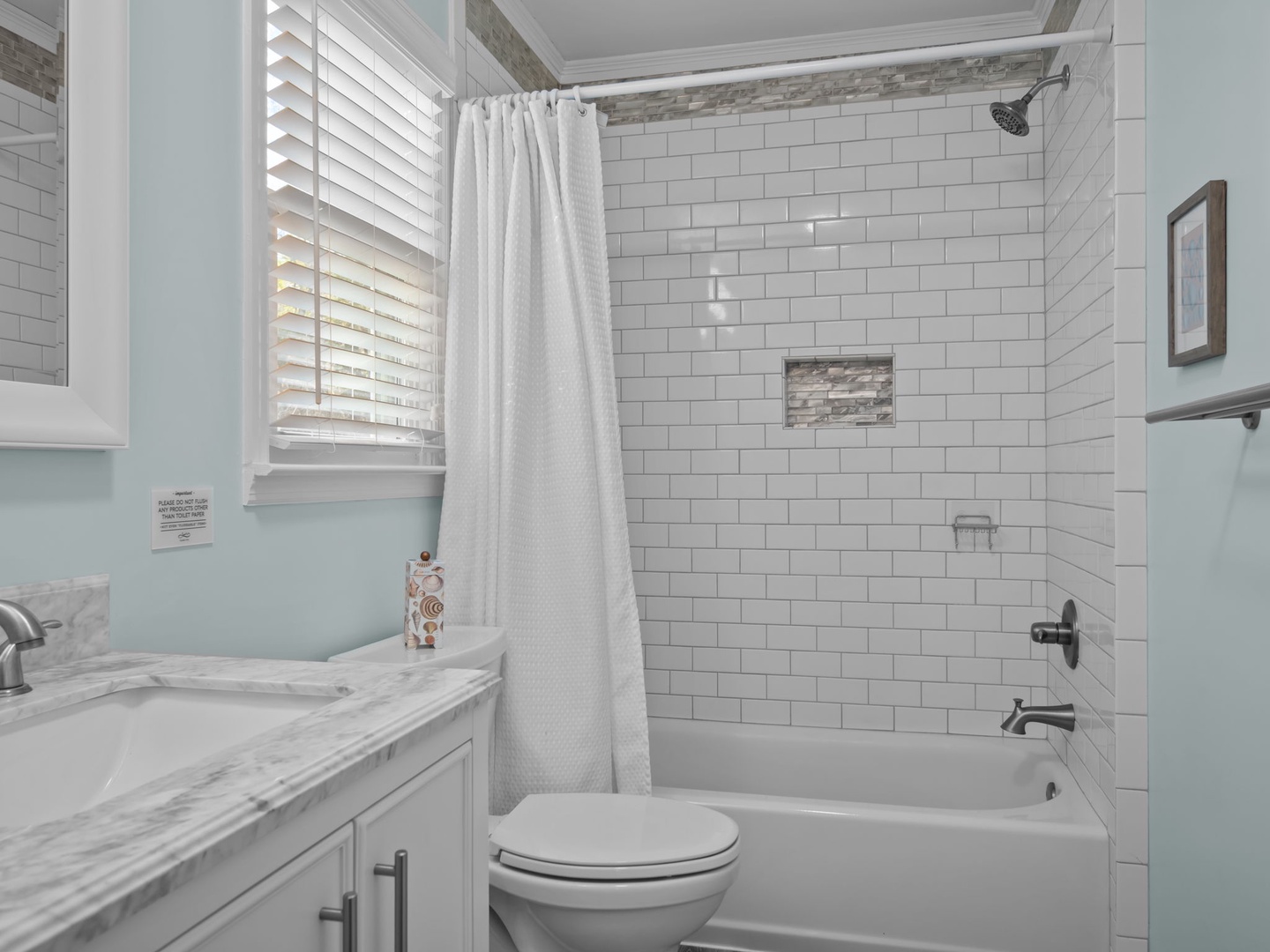 Refresh in your pristine bathroom with a luxurious tub-shower combo, elegant subway tiles, and soothing mint-green walls that create a spa-like retreat.