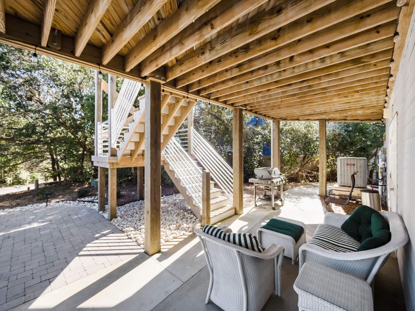 Relax in your private covered patio with comfortable wicker seating and BBQ access, perfect for peaceful outdoor moments.