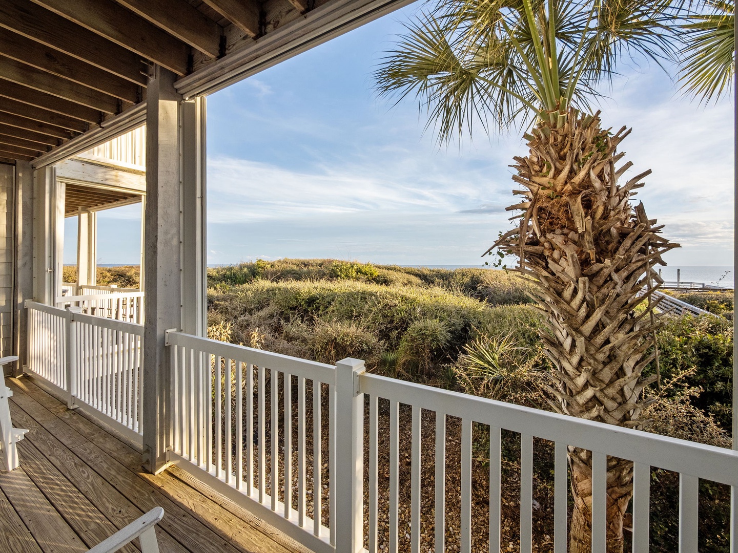 Relax on your private covered balcony overlooking coastal dunes and palm trees, perfect for morning coffee or evening unwinding.