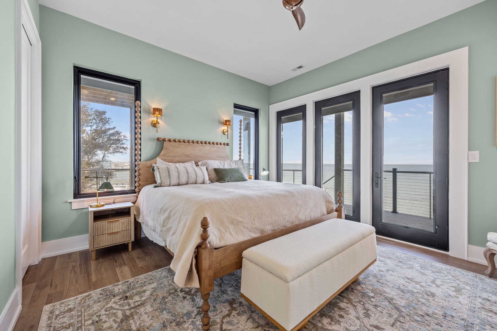 Wake up to stunning water views from your serene bedroom sanctuary, where soothing sage walls and coastal charm create the perfect retreat.