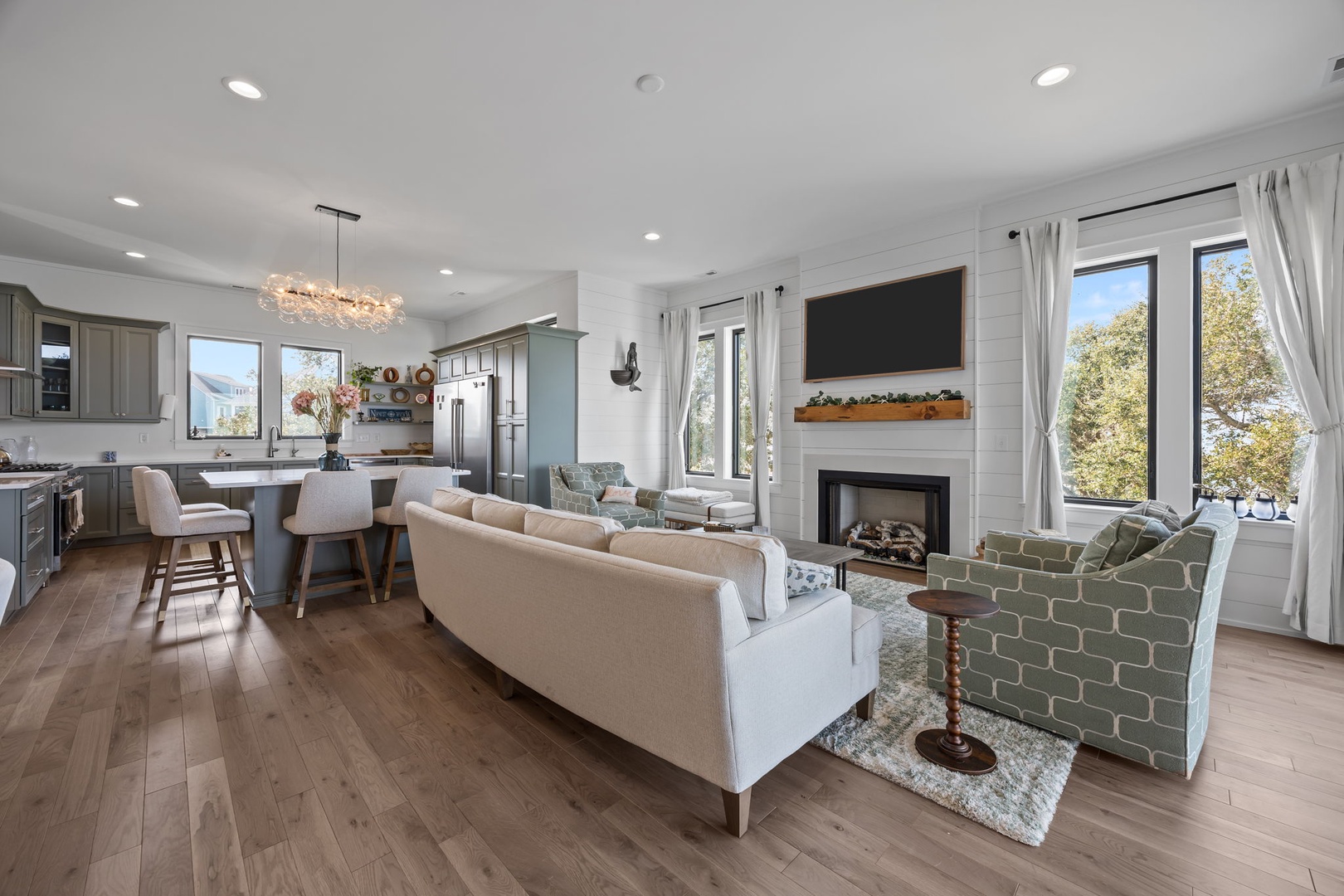 Your open-concept living space blends modern comfort with cozy touches—sink into plush seating by the fireplace while dinner simmers.