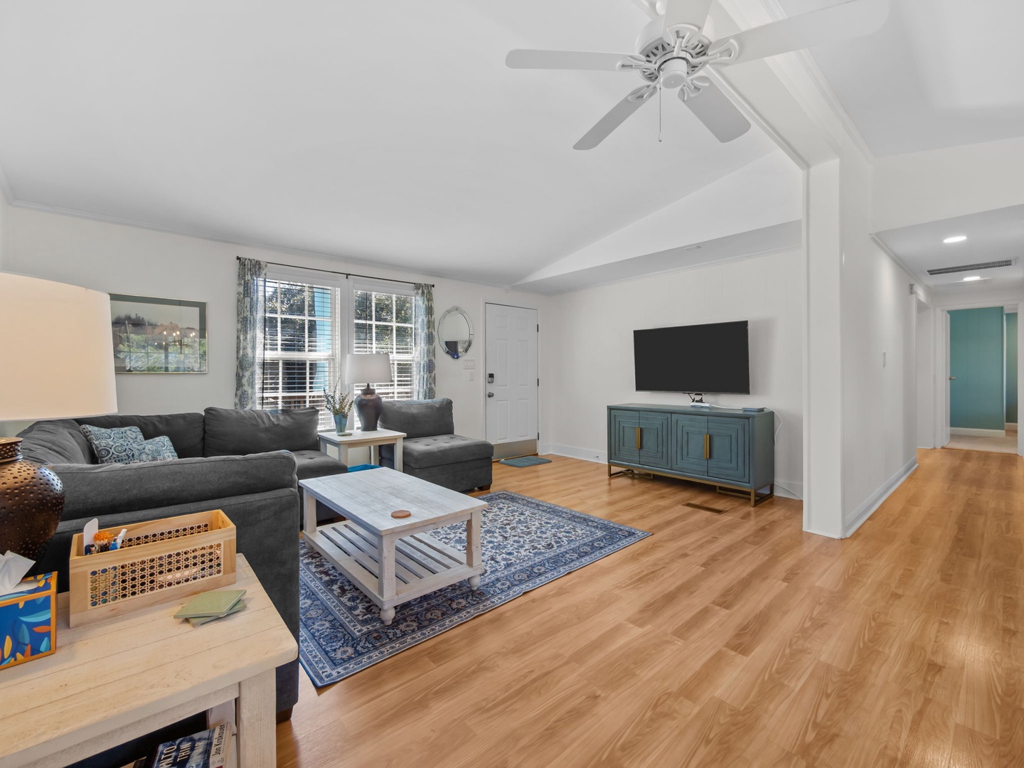 Relax in your spacious living room with plush sectional seating, warm hardwood floors, and modern entertainment center perfect for movie nights.