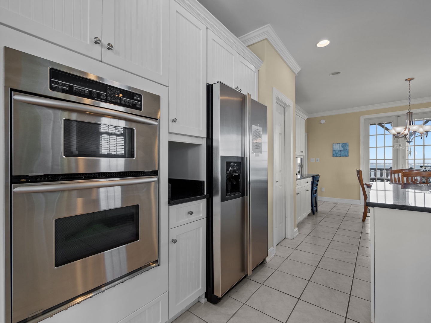 Your fully-equipped kitchen features stainless steel appliances, crisp white cabinetry, and seamless flow to the dining area for memorable meals.