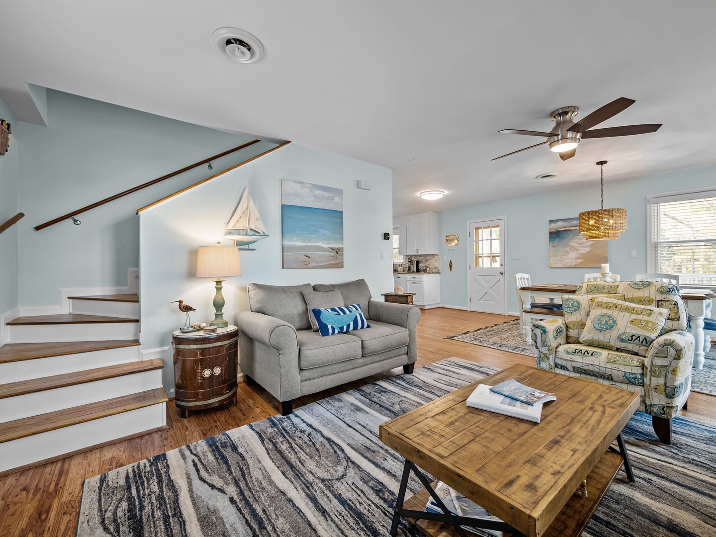 Unwind in your coastal living room featuring comfortable seating, nautical decor, and bright open-concept design perfect for relaxing.