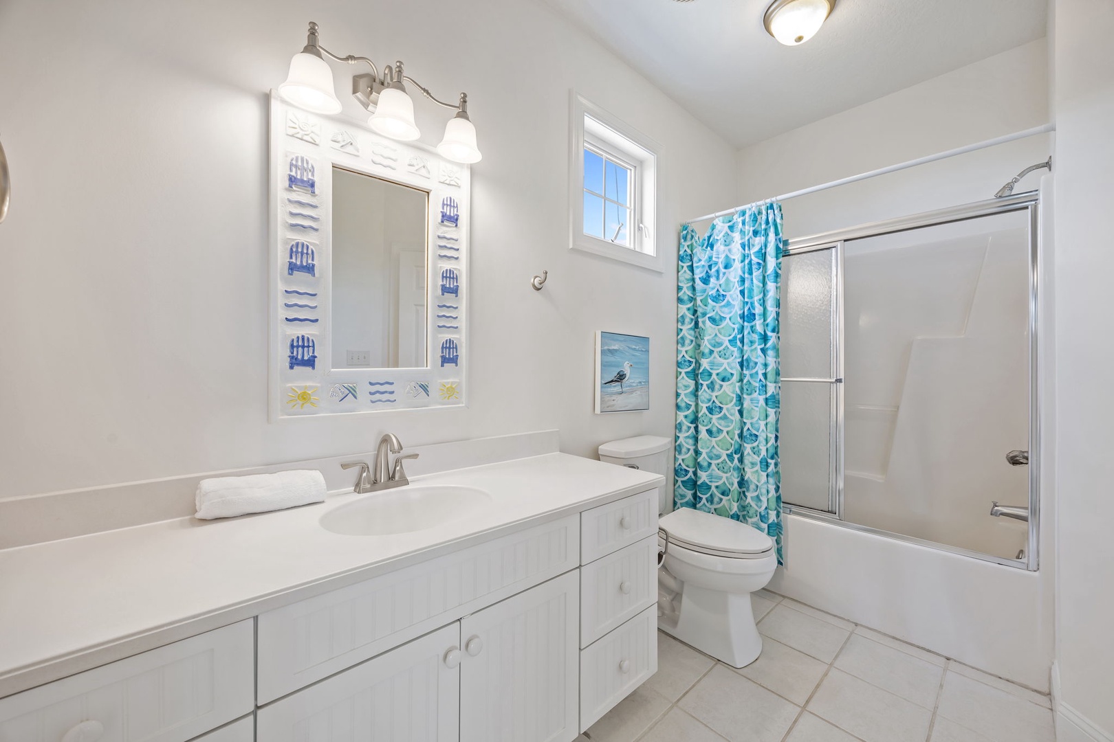 Step into your bright, coastal-themed bathroom with crisp white finishes and cheerful turquoise accents that make every morning feel refreshing.