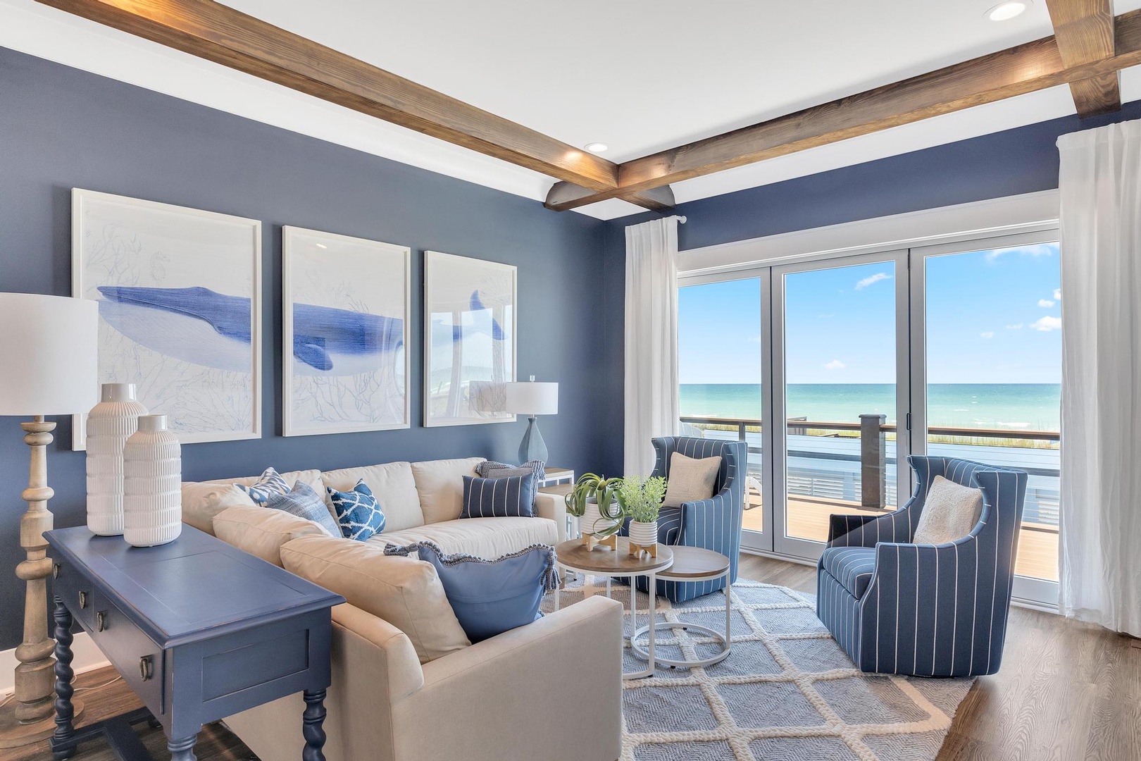 Step into this elegant living room where coastal blues and crisp whites meet warm wood accents. Your private sea-view terrace invites you to relax while soft textures create a soothing escape.