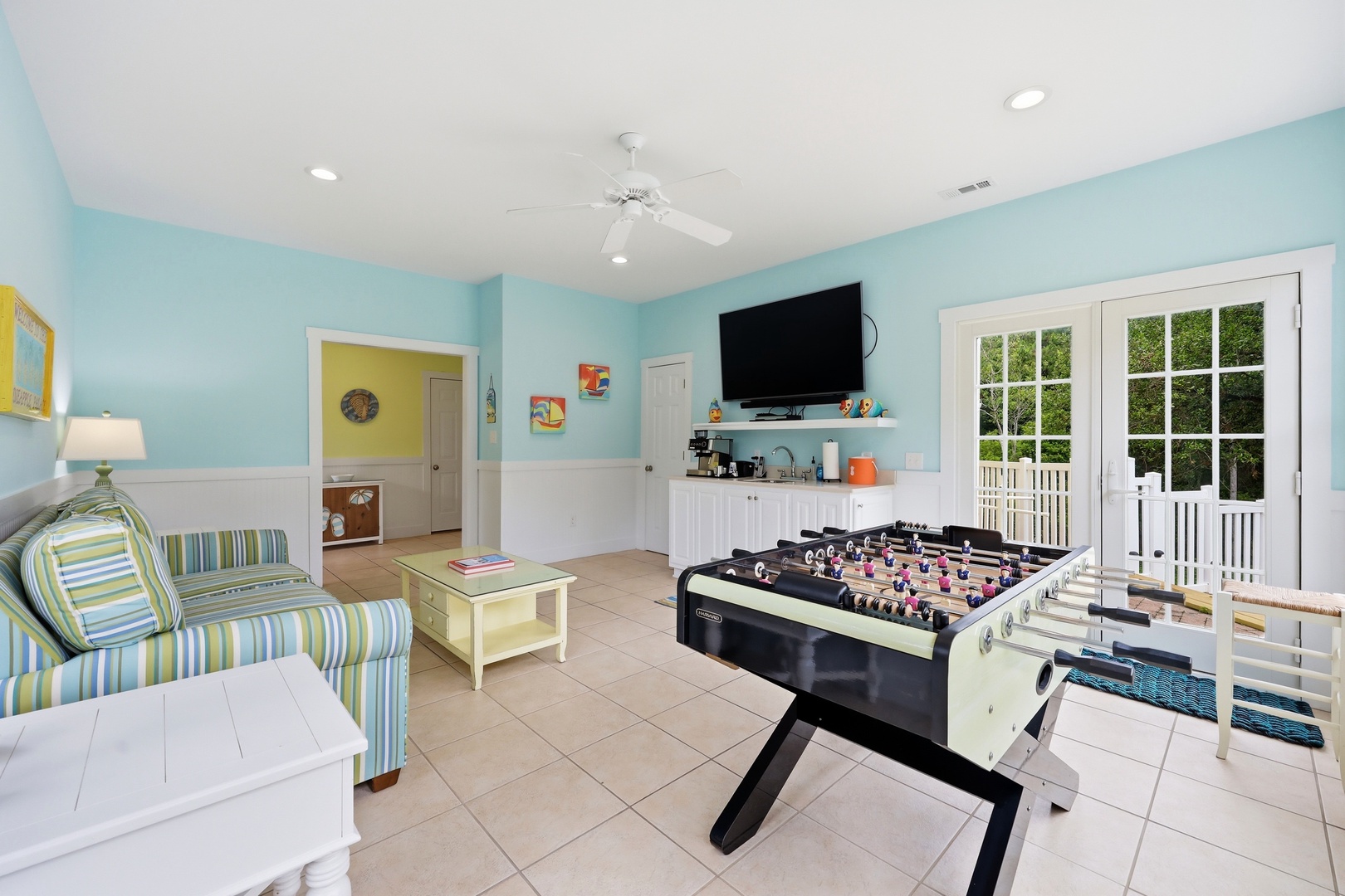 Step into your private game room where friendly competition awaits. Challenge your family to foosball, relax on comfy seating, catch a movie on the wall-mounted TV, or slip outside to your deck through elegant French doors.