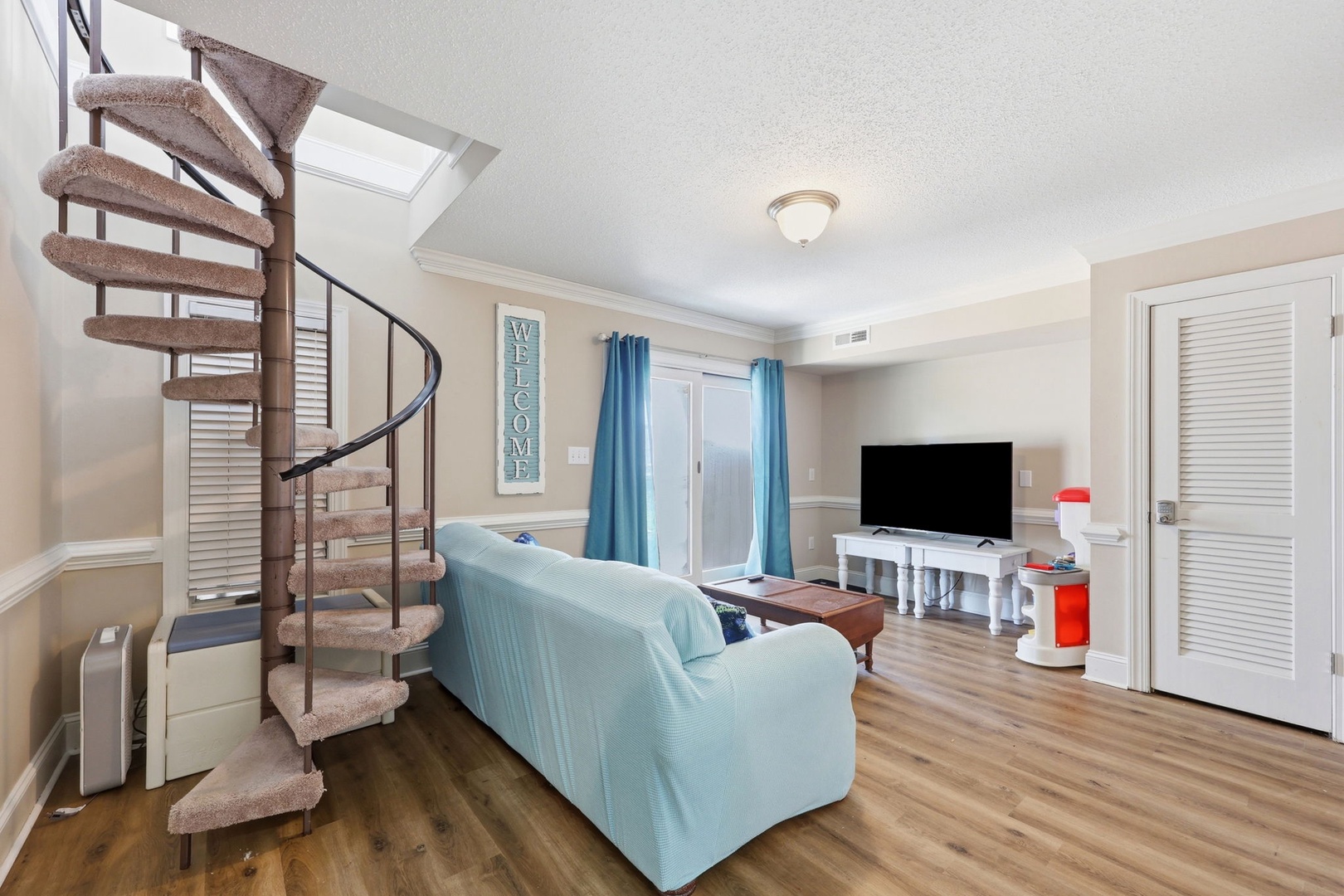 Relax on the plush sofa and enjoy the coastal-inspired living space, where natural light streams in and a charming spiral staircase invites you to explore.