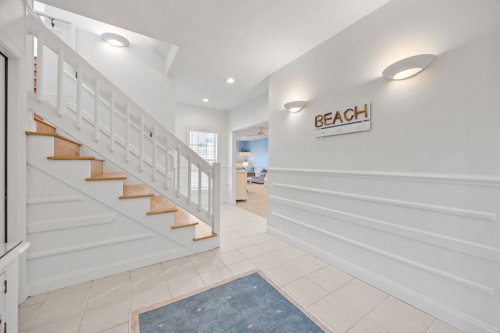 Step into your bright coastal retreat where crisp white walls and warm wood accents create the perfect beach house welcome.