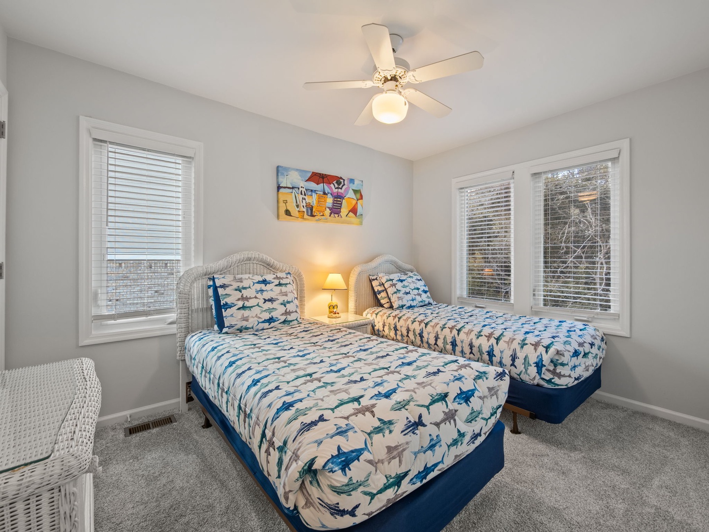 Your bright twin bedroom features playful shark-themed bedding and wicker furniture, creating the perfect coastal hideaway for kids or friends.