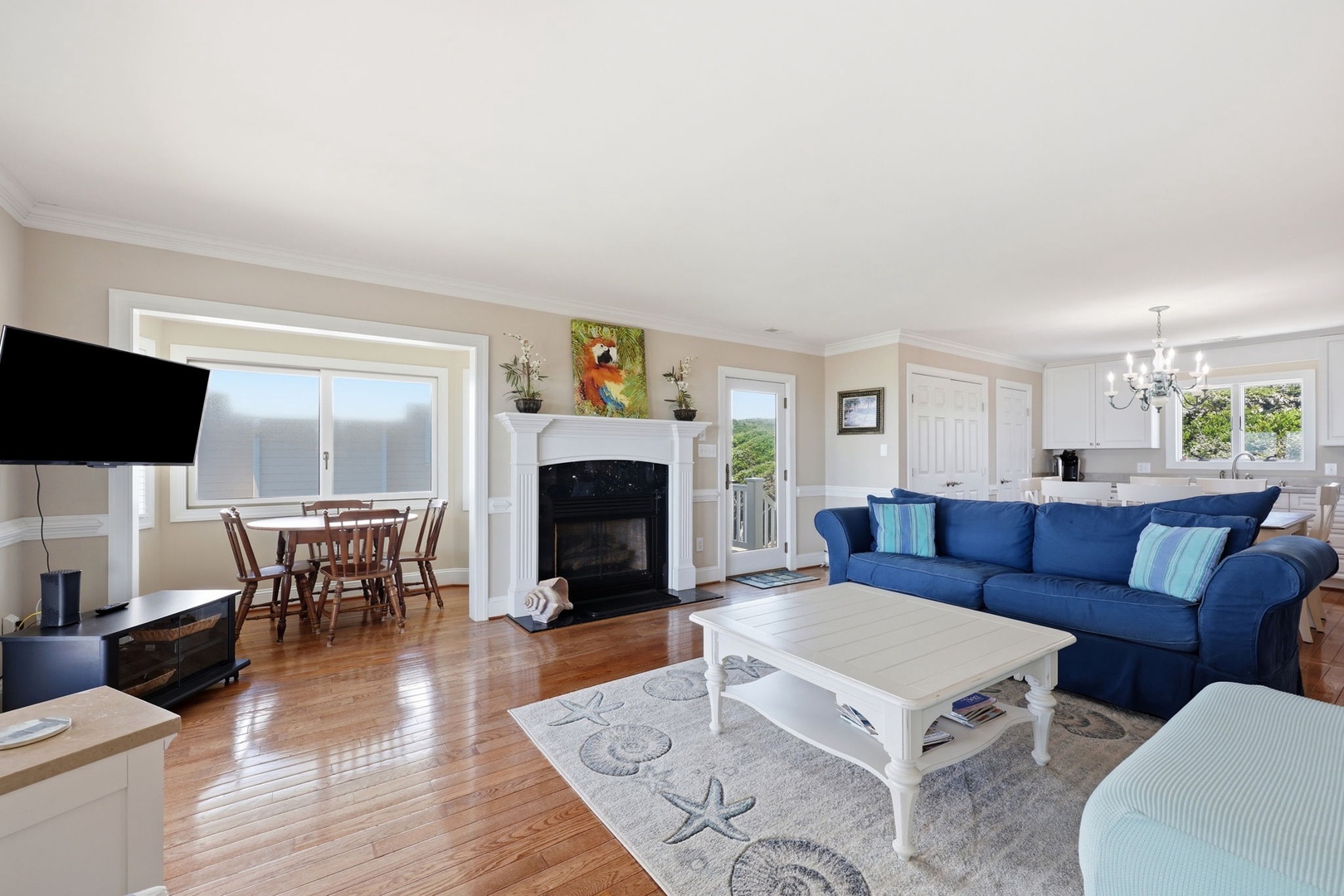 Sink into the plush blue sofa and let the ocean views through bright windows fill your senses. Warm wood floors and coastal touches create your perfect home away from home.