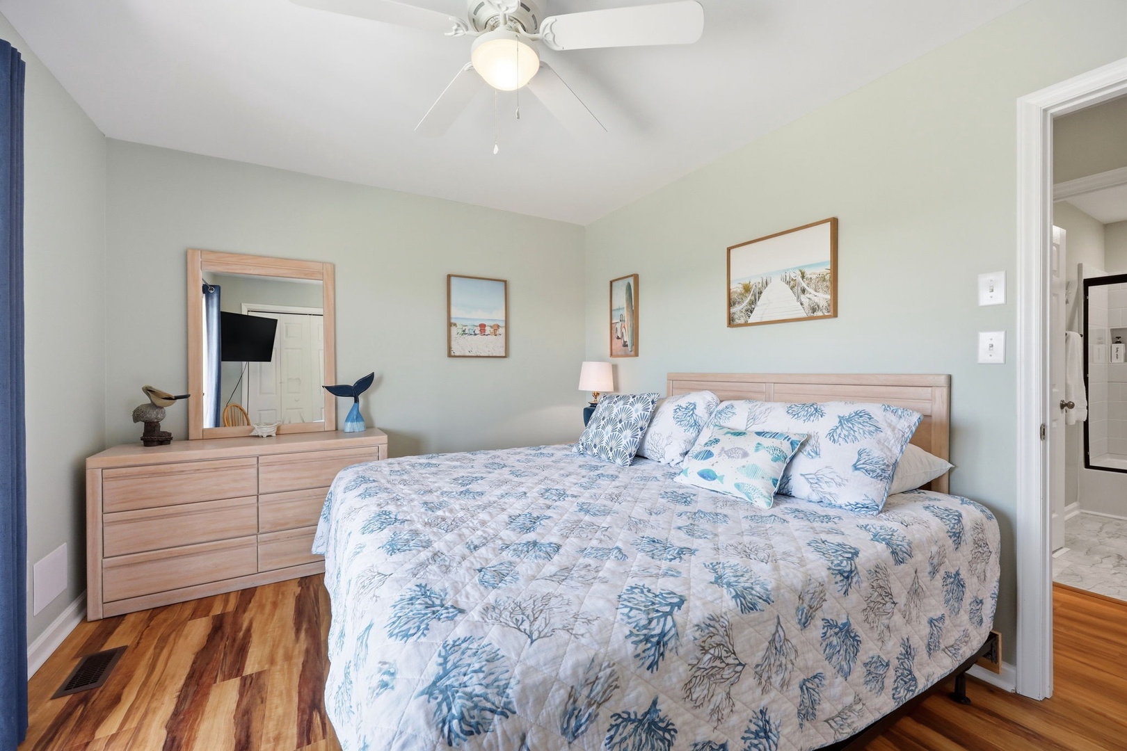 Settle into your peaceful retreat with soft coastal bedding, warm wood tones, and a ceiling fan to keep you comfortable. Beach-inspired decor and gentle hues create a soothing escape after your adventures.