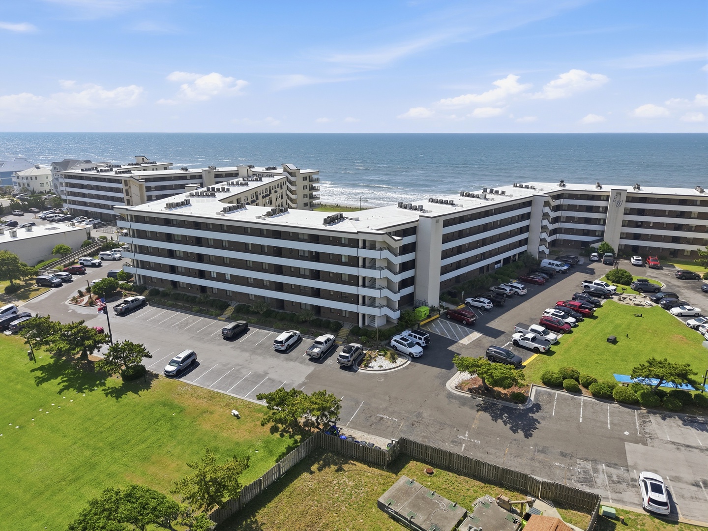 Beachfront property complex positioned directly on the sandy shore, surrounded by landscaped grounds and offering convenient parking and coastal access.