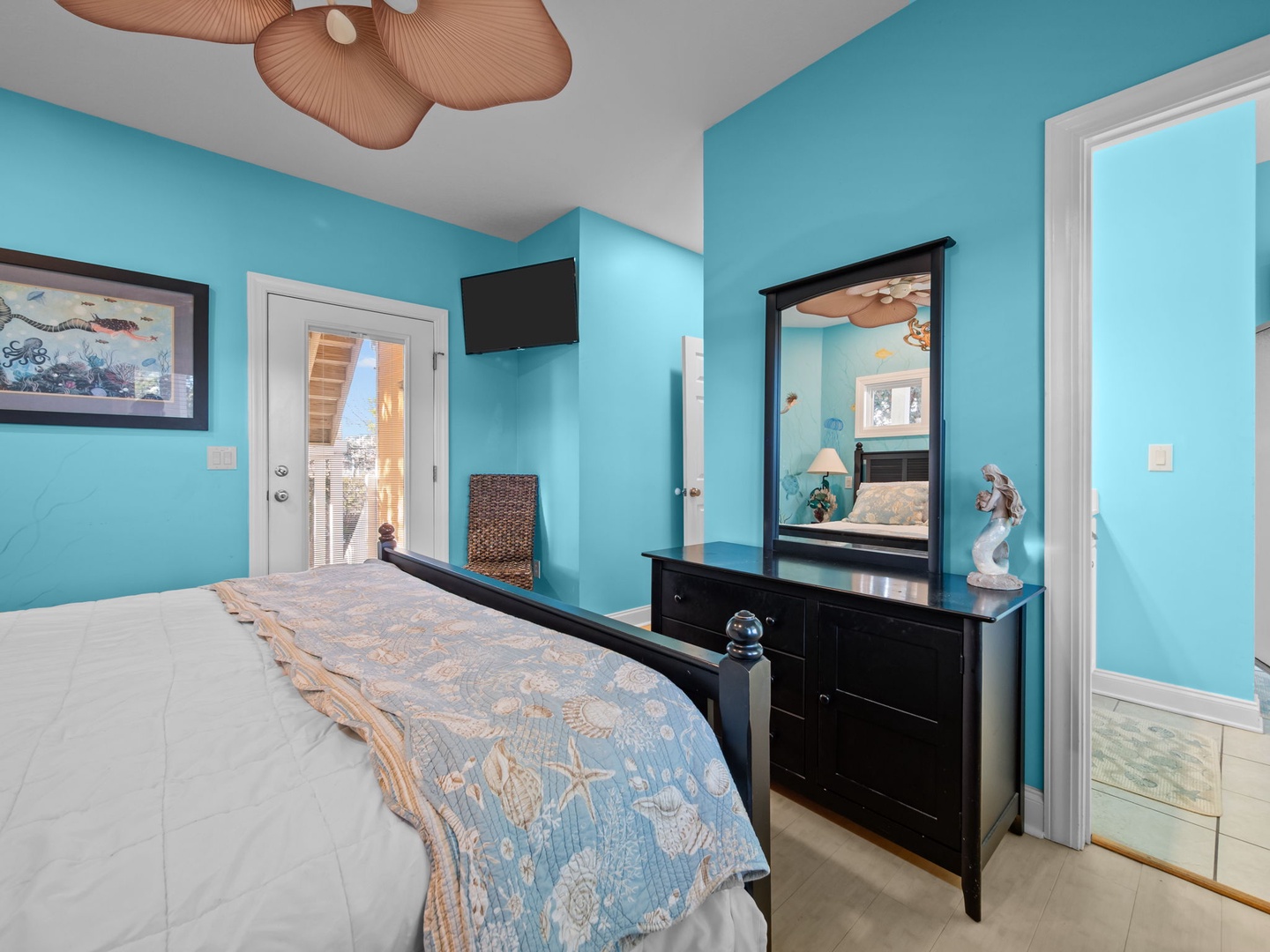 Drift off in your tropical-themed bedroom with ocean-blue walls and coastal touches creating a serene seaside retreat.
