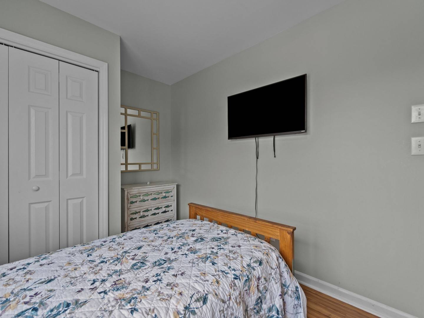 Unwind in your peaceful bedroom featuring a comfortable bed, wall-mounted TV for entertainment, and ample storage space for all your belongings.