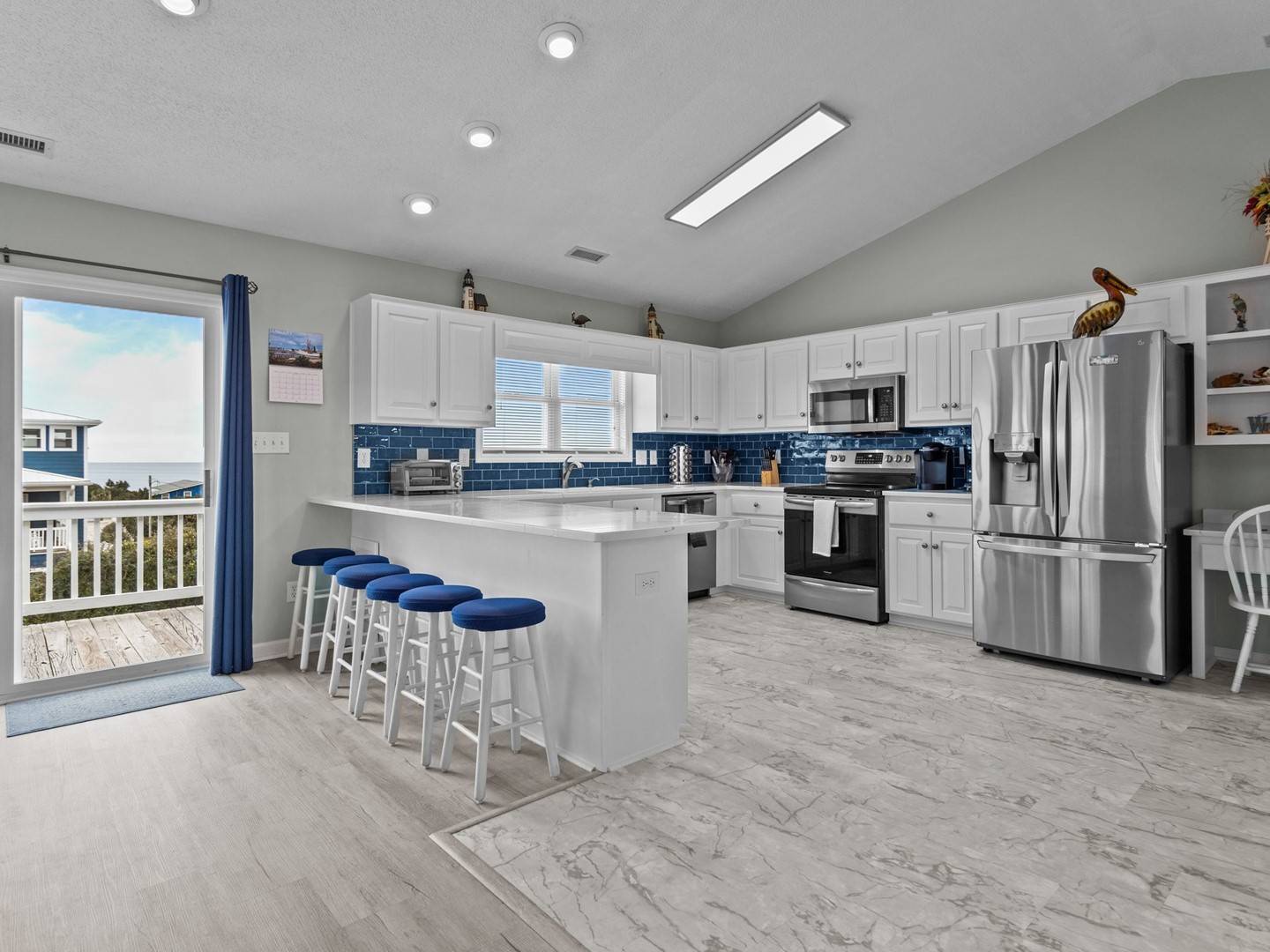 Your fully equipped kitchen features stainless appliances, granite counters, and a breakfast bar perfect for morning coffee with ocean views.