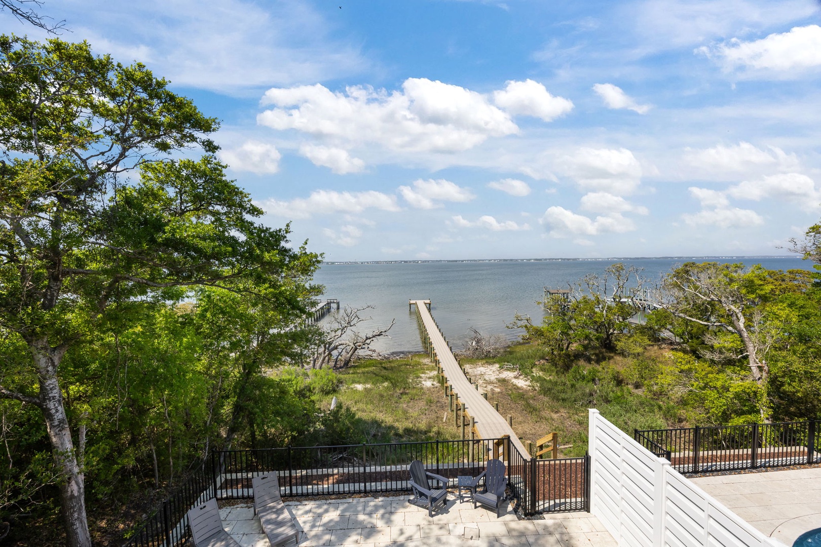 Waterfront property featuring private beach access via wooden boardwalk through natural coastal landscape.