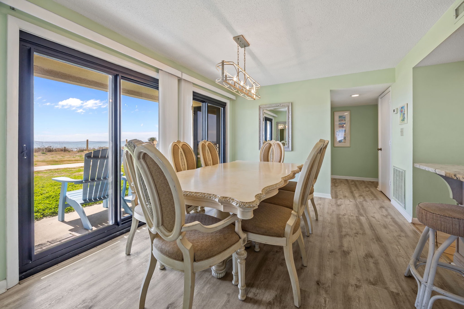 Gather around your elegant dining table with sweeping views through floor-to-ceiling windows, perfect for memorable meals together.