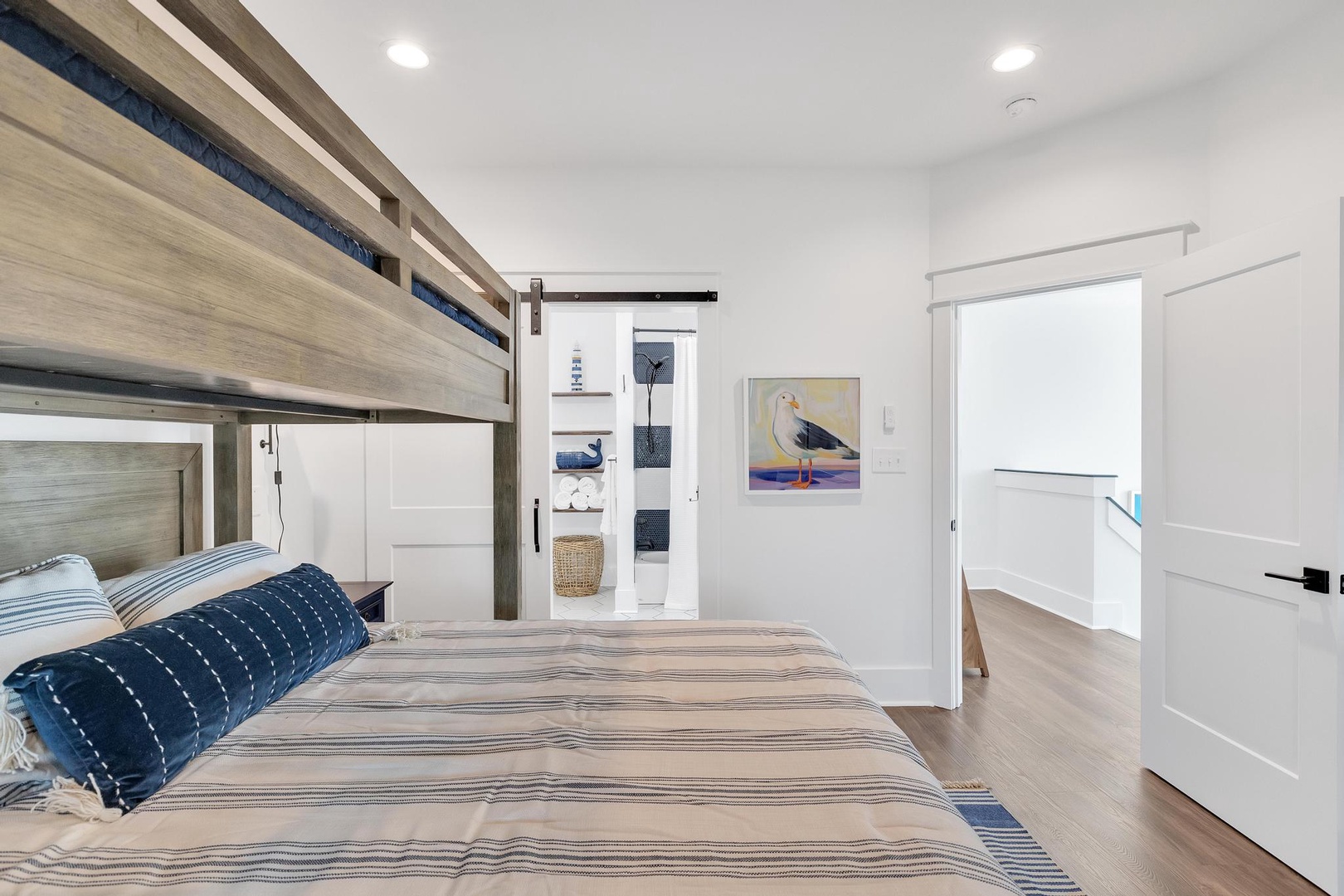 Snuggle into crisp linens beneath a charming bunk, where coastal artwork and natural light create your restful seaside retreat.