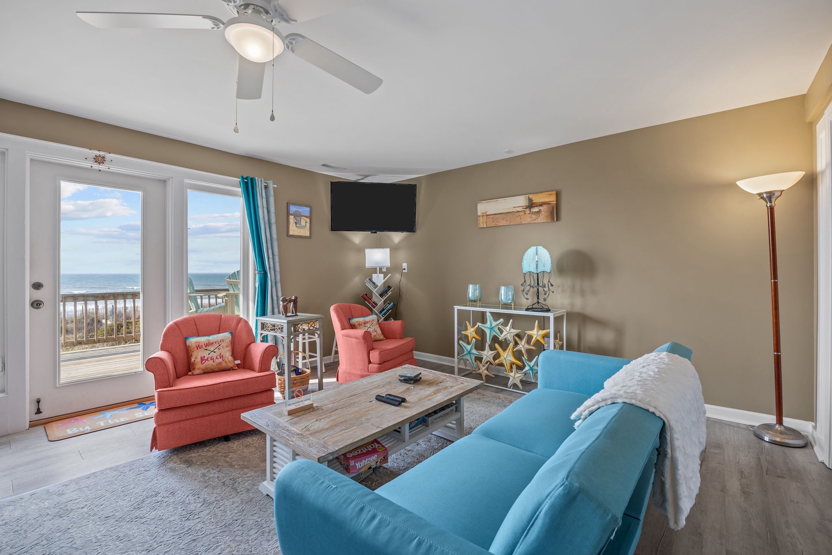 Relax in your bright living room with stunning ocean views through sliding glass doors and cozy seating for memorable moments.