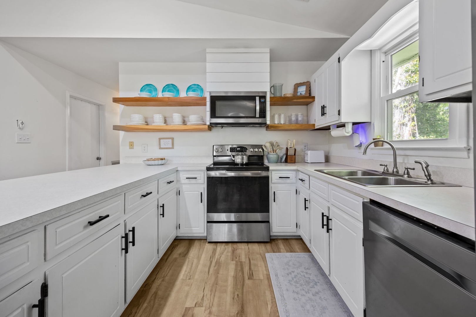 Your bright, fully-equipped kitchen invites culinary adventures with modern appliances, ample counter space, and charming open shelving for easy meal prep.