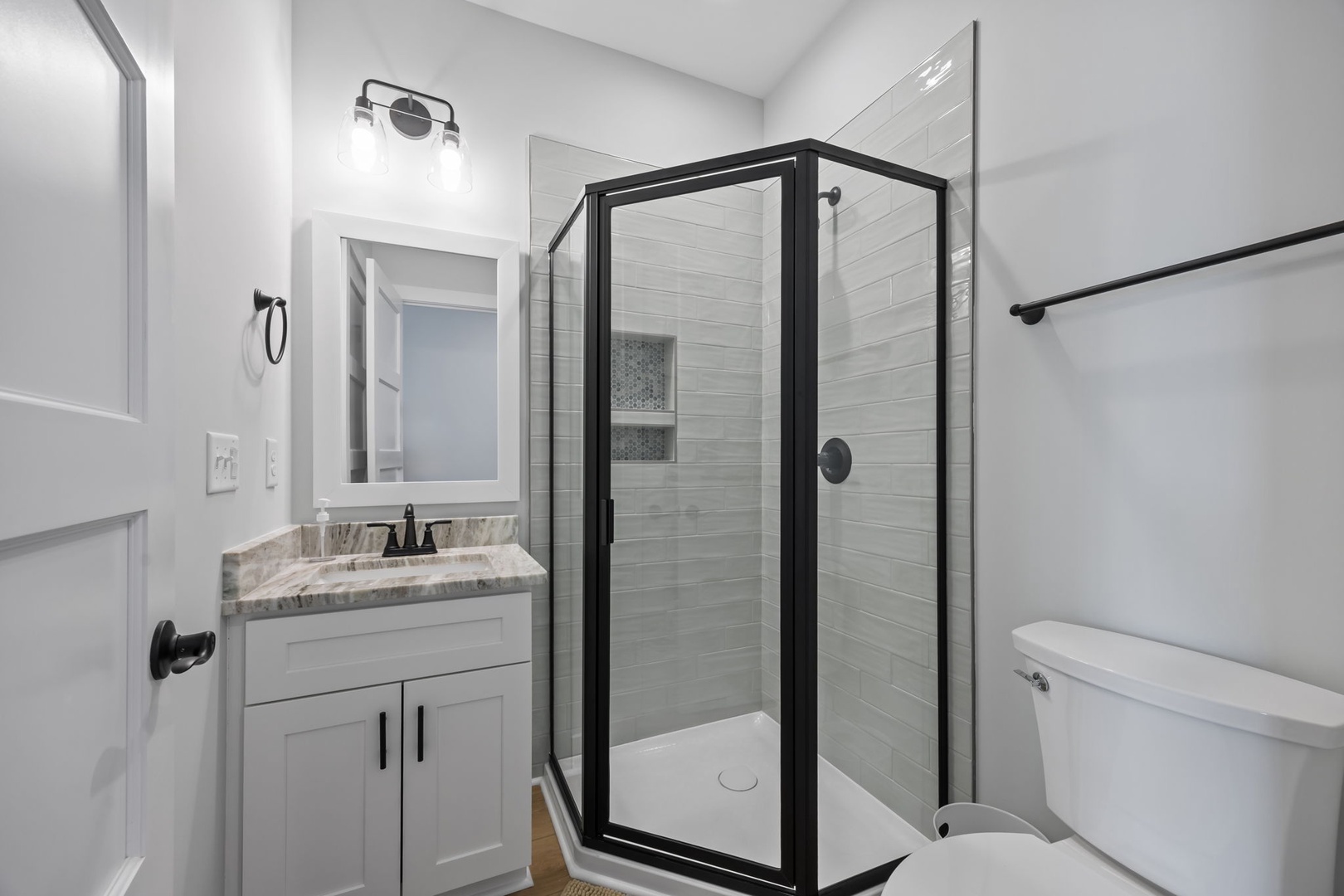 Step into your pristine bathroom featuring elegant marble countertops, a spacious glass shower with modern fixtures, and thoughtful design touches.