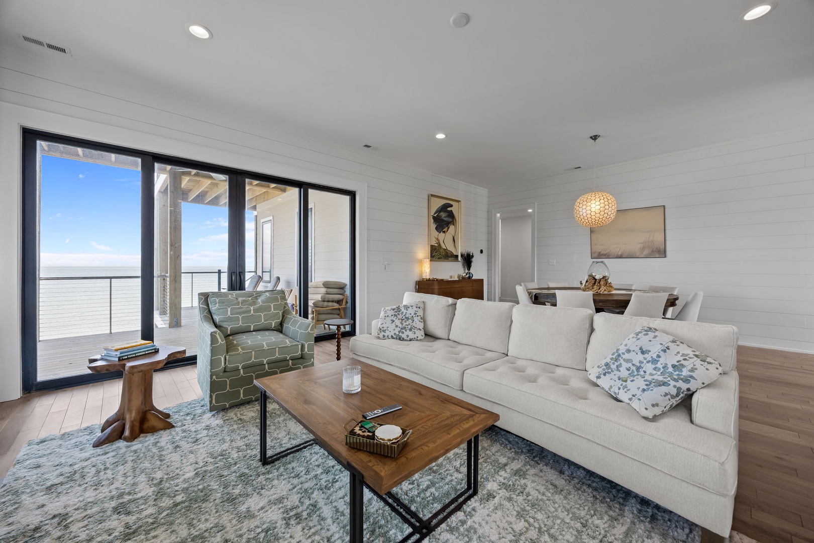 Sink into plush seating while ocean breezes flow through your stylish living space, where modern comfort meets breathtaking coastal views.