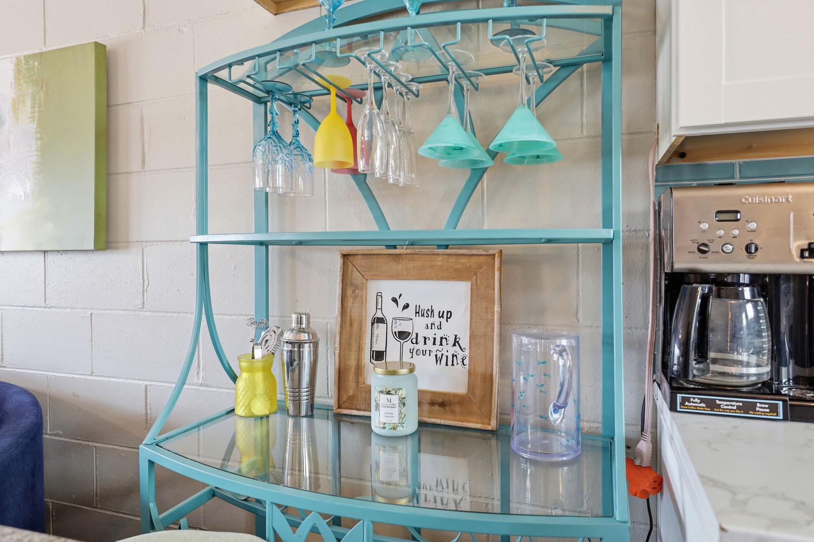 A charming turquoise bar cart awaits your evening cocktails, with glassware and wine accessories ready for you to unwind and sip in style.