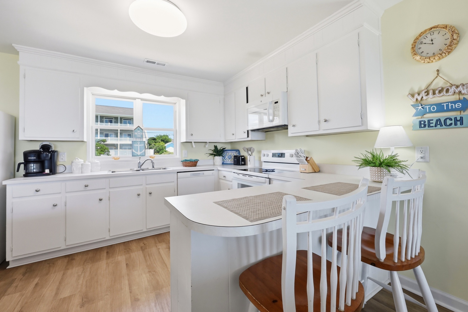Picture yourself preparing meals in this bright, coastal-inspired kitchen with beach views inviting you to unwind. The open layout and cheerful décor create a welcoming space where your vacation memories begin.