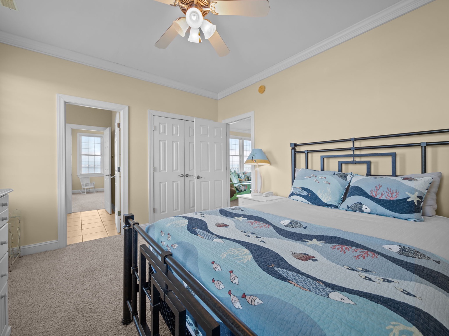 Drift off to sleep in your cozy coastal-themed bedroom, where ocean-inspired bedding and gentle ceiling fan create perfect comfort.