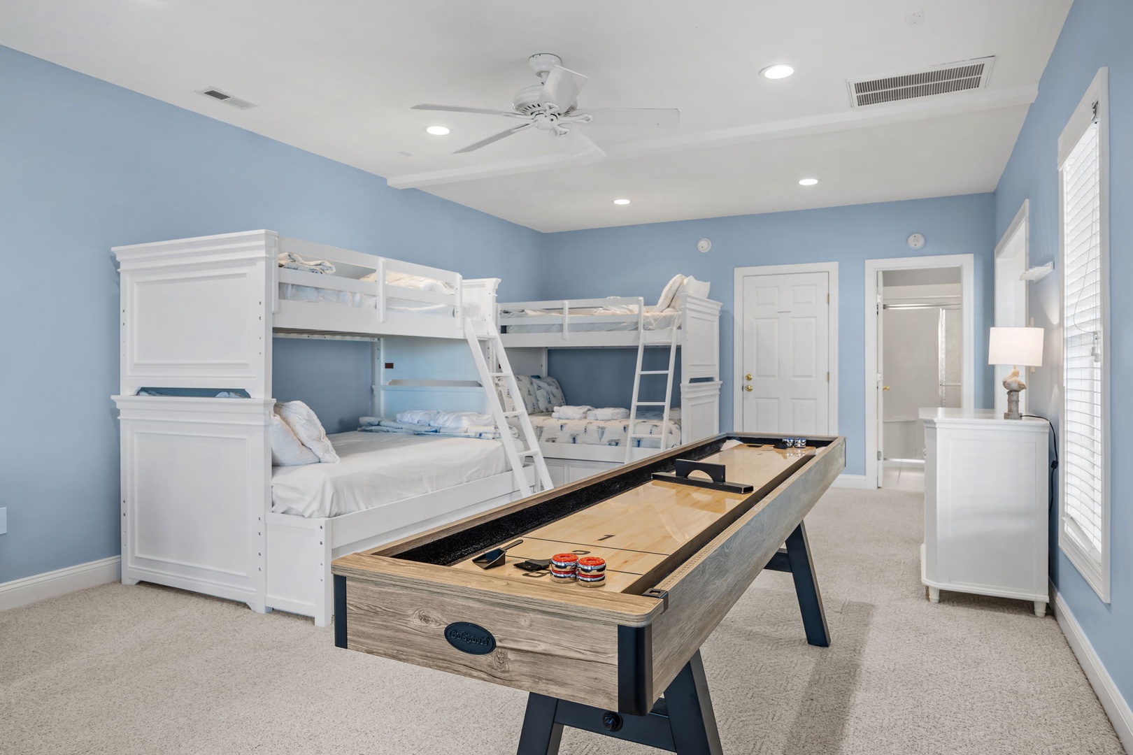 Your kids will love this cheerful bedroom with bunk beds and a shuffleboard table for endless fun.