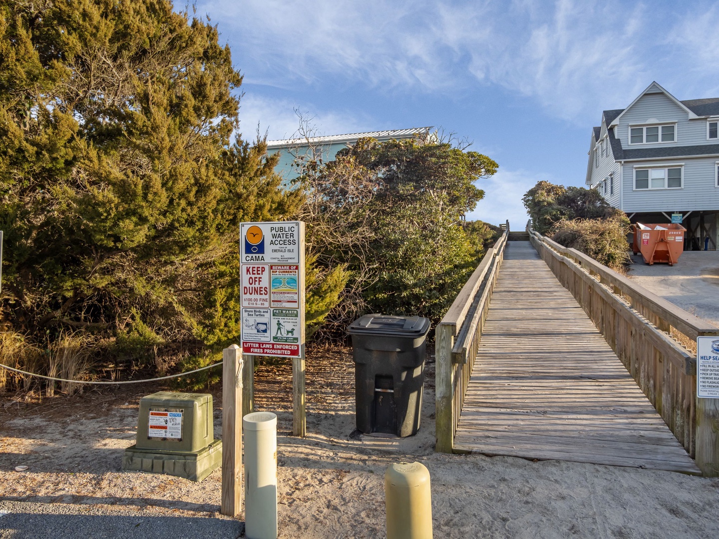 Coastal beach access with boardwalk and nearby vacation homes in a quiet residential area.