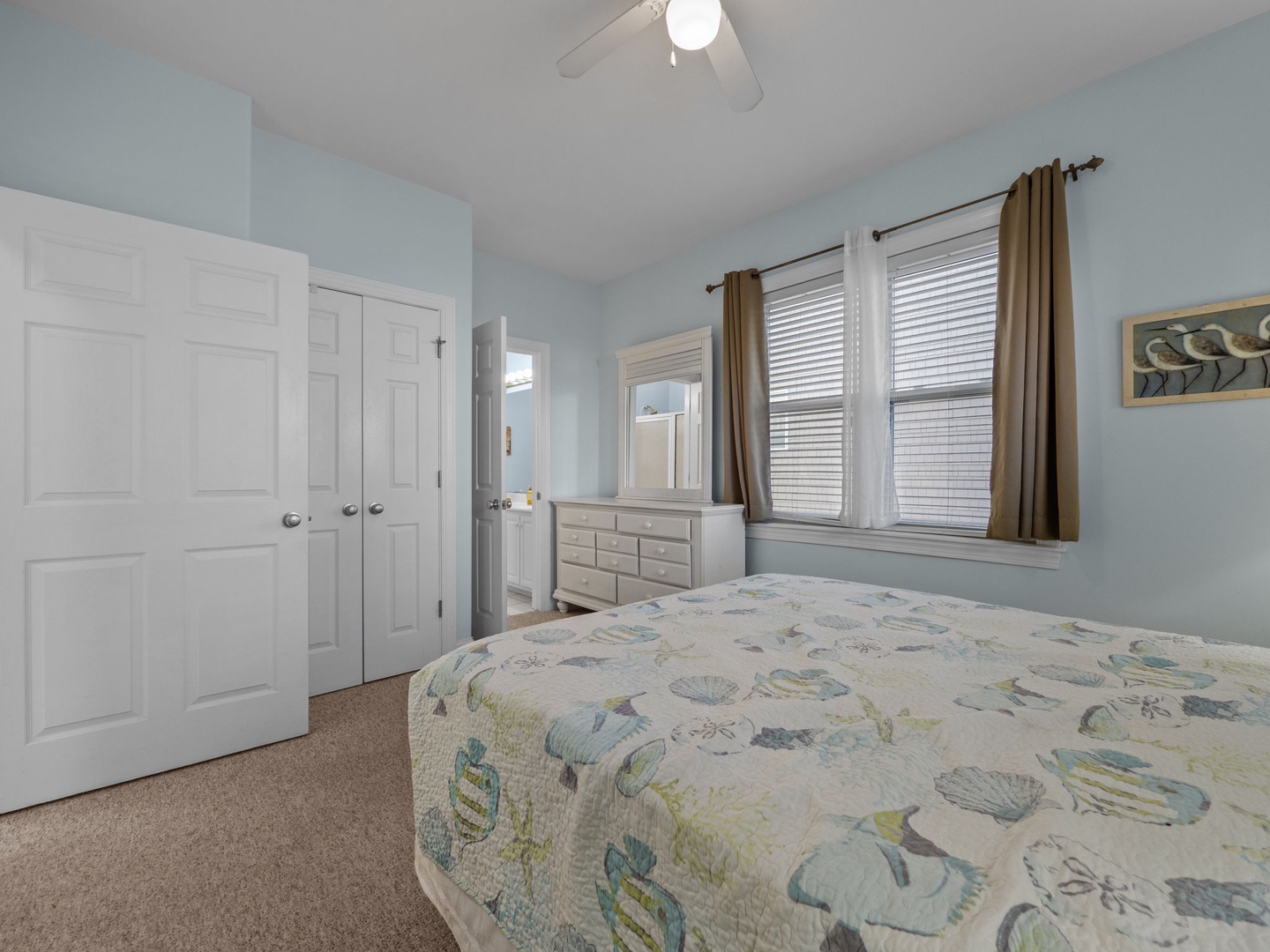 Drift off to sleep in this tranquil coastal bedroom where soft blues and ocean-themed bedding create your perfect seaside sanctuary.