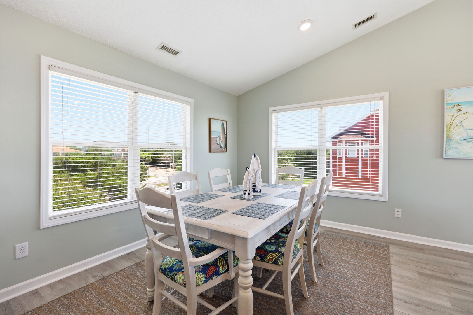 Gather around this inviting dining table with coastal views stretching through the windows. Soft natural light fills your space while you enjoy meals with loved ones in this serene setting.