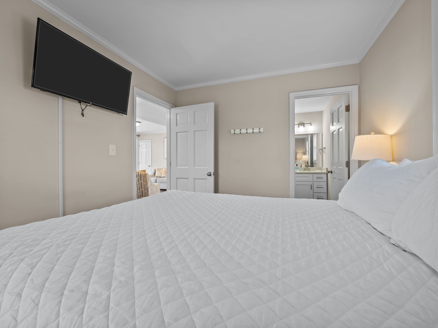 Sink into crisp white linens in your serene bedroom, where warm lighting and your private en-suite await.