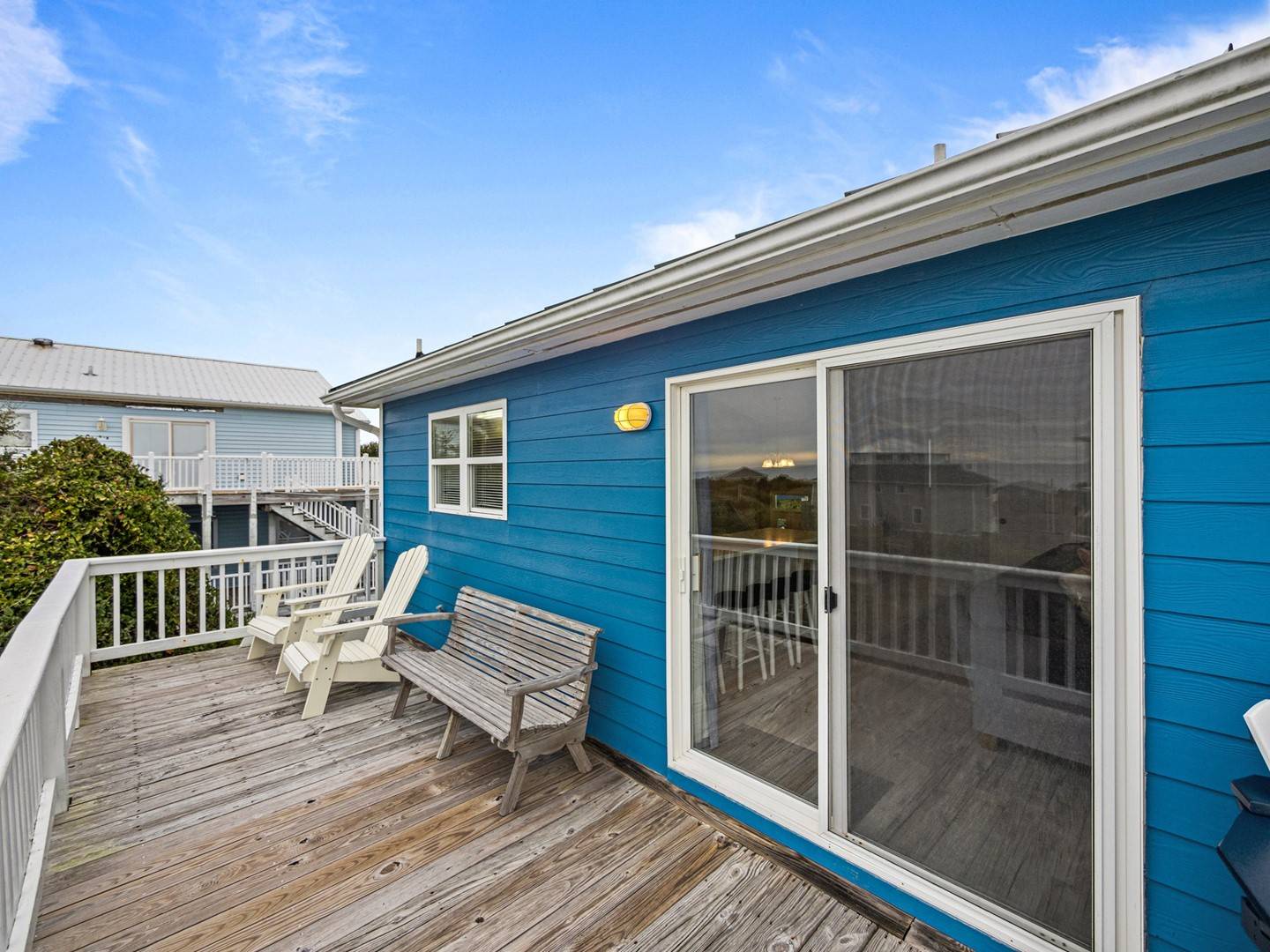 Relax on your private deck with comfortable seating and sliding door access to your coastal retreat.