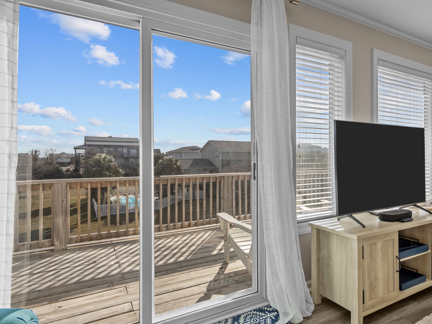 Enjoy peaceful mornings with your coffee on this sunny deck, overlooking the quiet neighborhood through floor-to-ceiling windows.