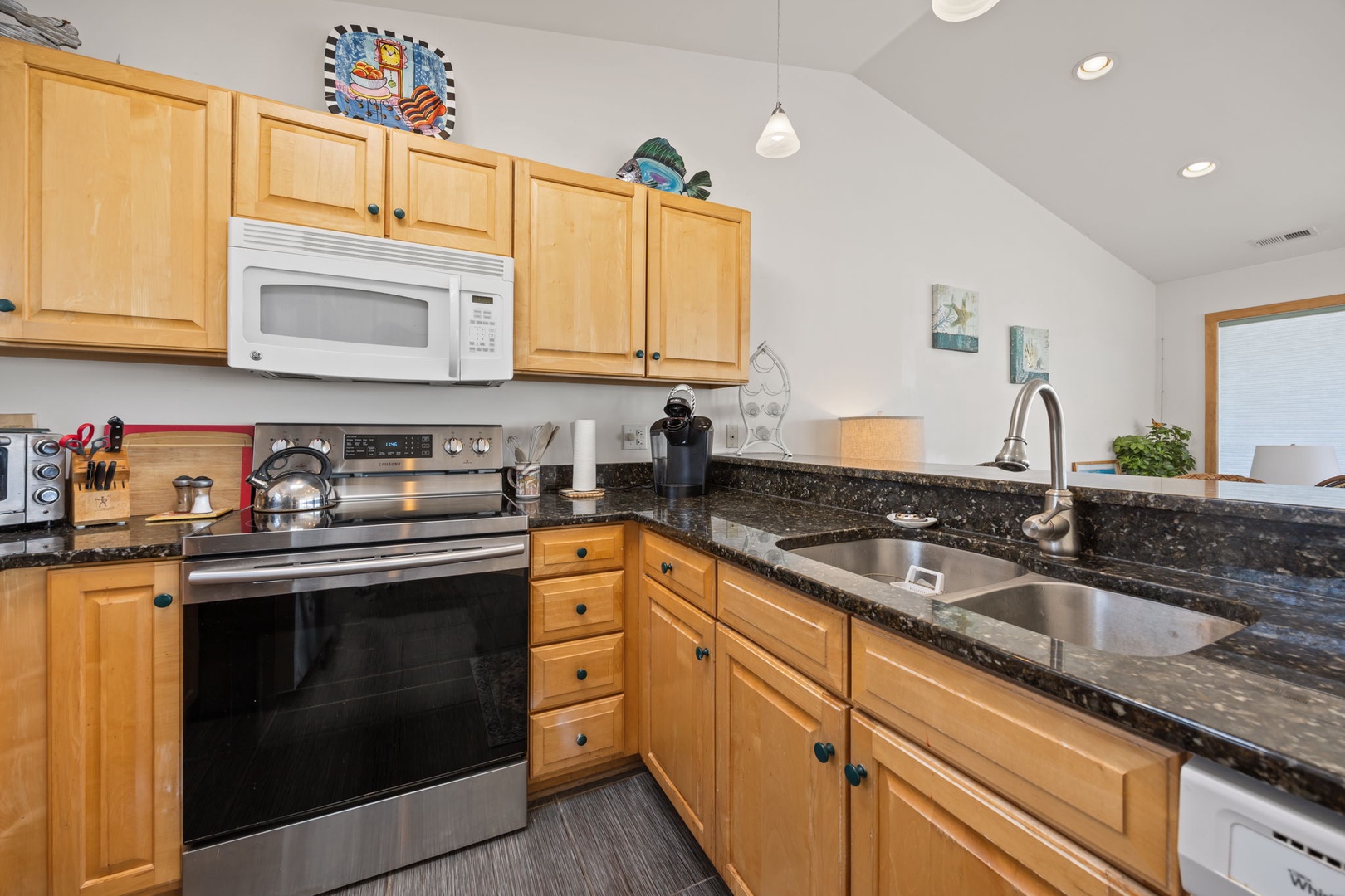 Your fully equipped kitchen features granite countertops, stainless steel appliances, and warm wood cabinetry—perfect for creating memorable meals together.