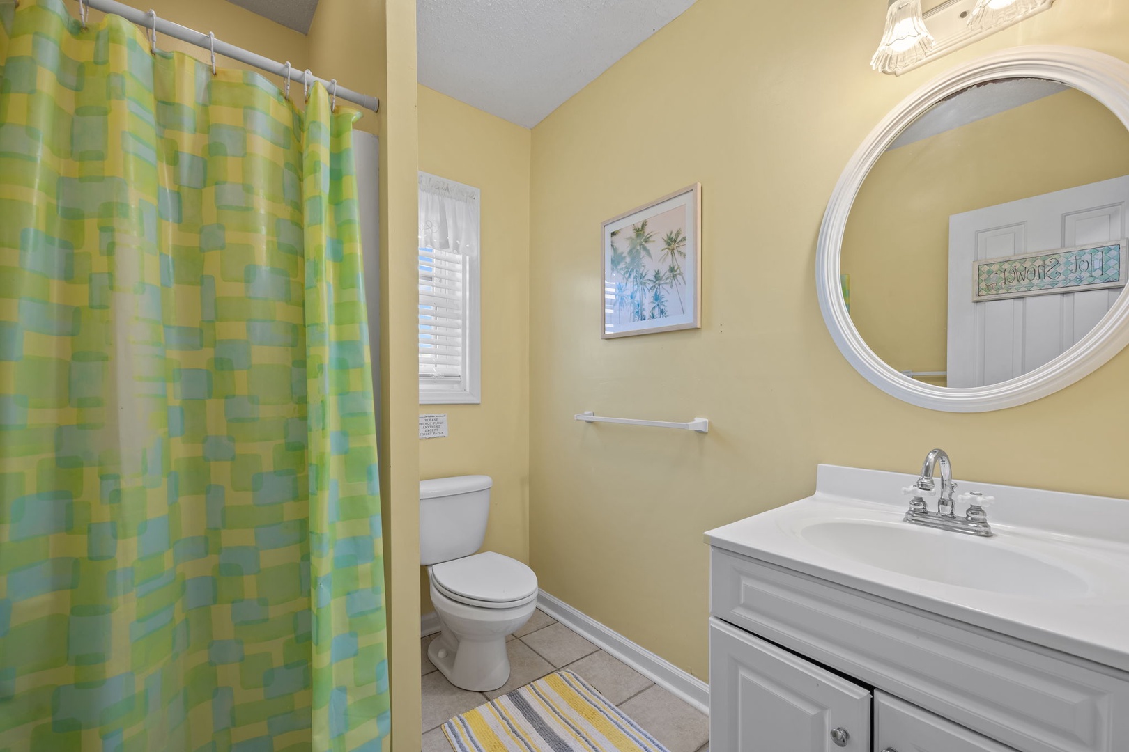 Your bright, cheerful bathroom features a refreshing shower, modern vanity, and coastal-inspired décor that sets a relaxing vacation mood.
