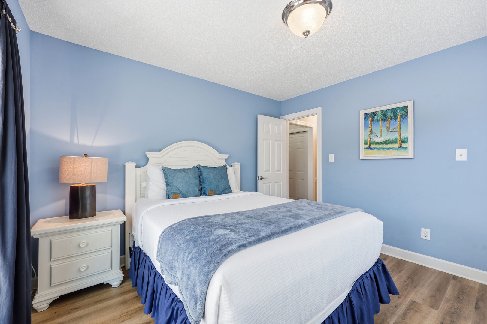 Sink into soft linens and coastal charm in this serene bedroom, where soothing blue tones and gentle lighting create your perfect retreat after a day of adventure.