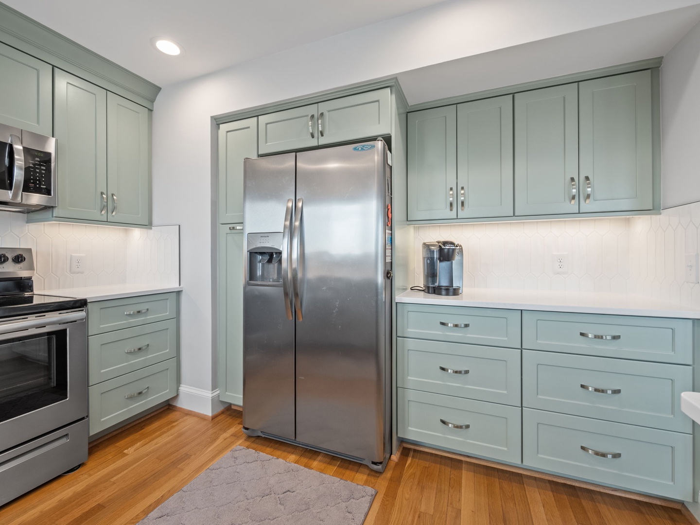 Your fully equipped kitchen features sage green cabinets, stainless steel appliances, and ample counter space for preparing memorable meals.