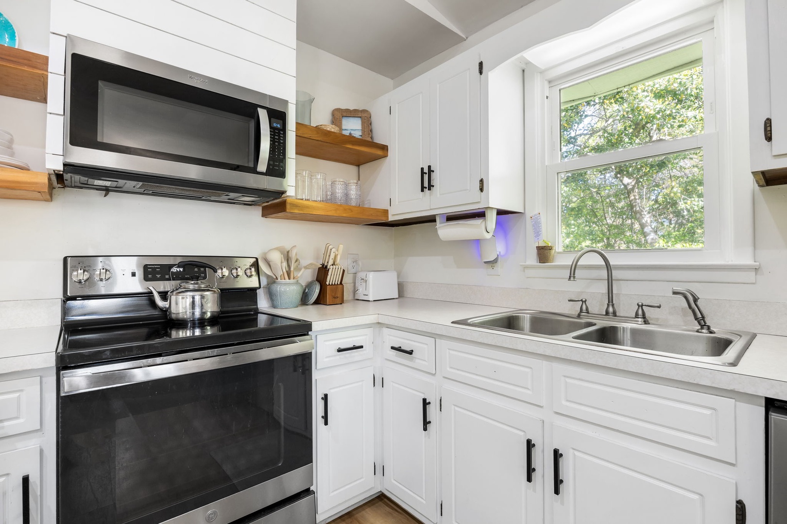 Cook your favorite meals in this bright, fully-equipped kitchen with modern appliances and charming garden views from the window.